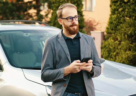 Man holding his phone waiting for AA patrol outside his home