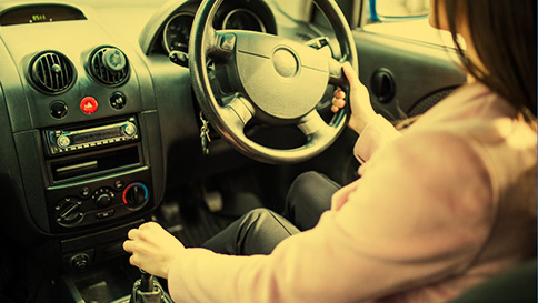 A young driver restarting her car after stalling