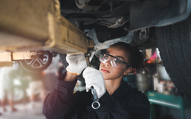 A mechanic working underneath a car